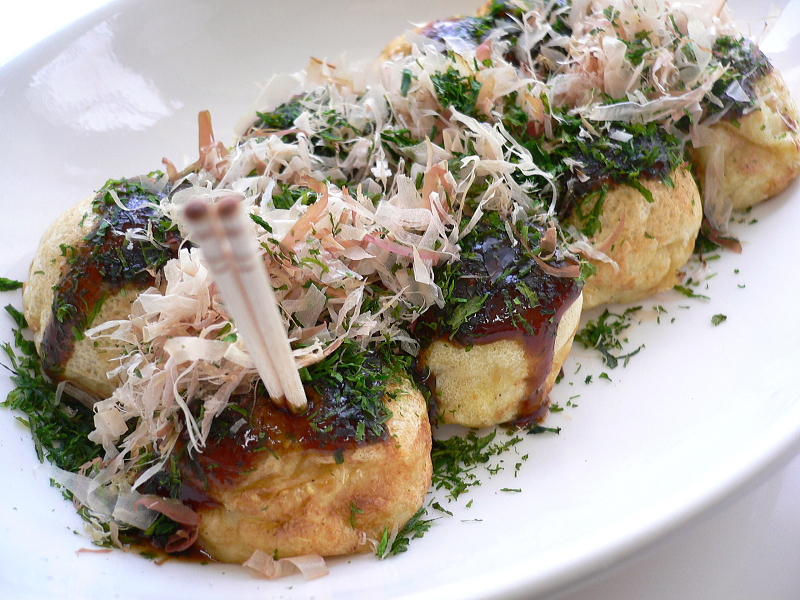 ソースとかつお節がたっぷりかかった焼きたてのたこ焼き